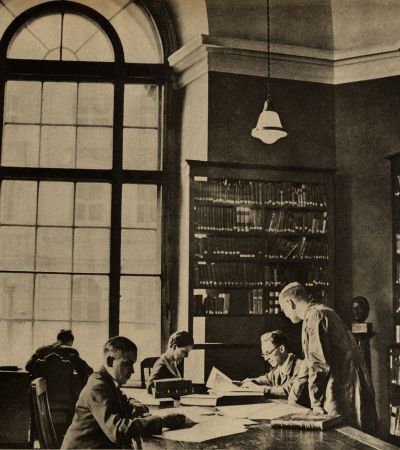 Lotte Hüttebräuker (1902–1945) auf (gestelltem) Foto in MGH-Bibliothek in Berlin 1934 (v.l.n.r.): Karl Jordan, Lotte Hüttebräuker, Otto Meyer, Heinrich Büttner, Carl Erdmann.